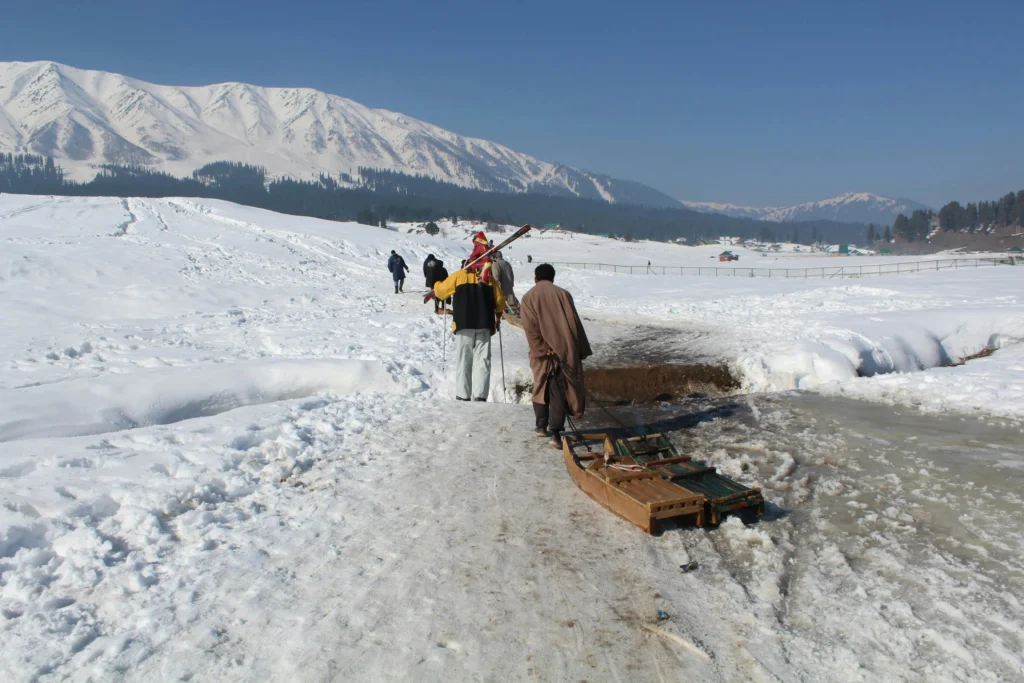 Man pulling a sled across a snowy landscape in Alaska for a winter adventure