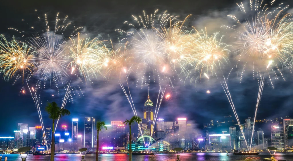 Victoria Harbour skyline lit with New Year’s Eve fireworks and skyscraper light displays in Hong Kong